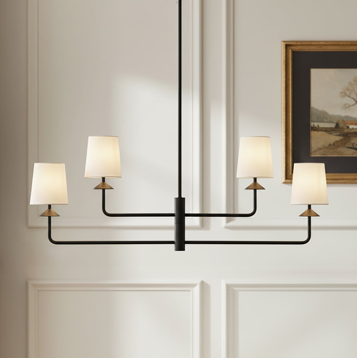 Modern adjustable arm chandelier with four lights and white fabric shades in a transitional room with art.