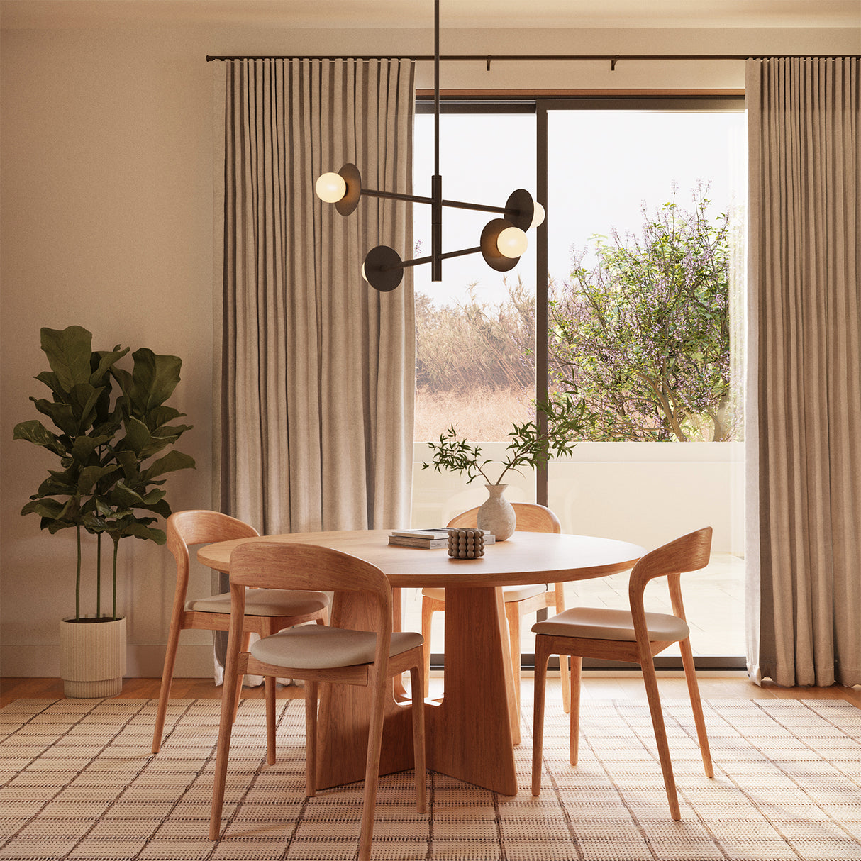 Sol LED chandelier in black is hung above a modern round dinning table with seating for four.