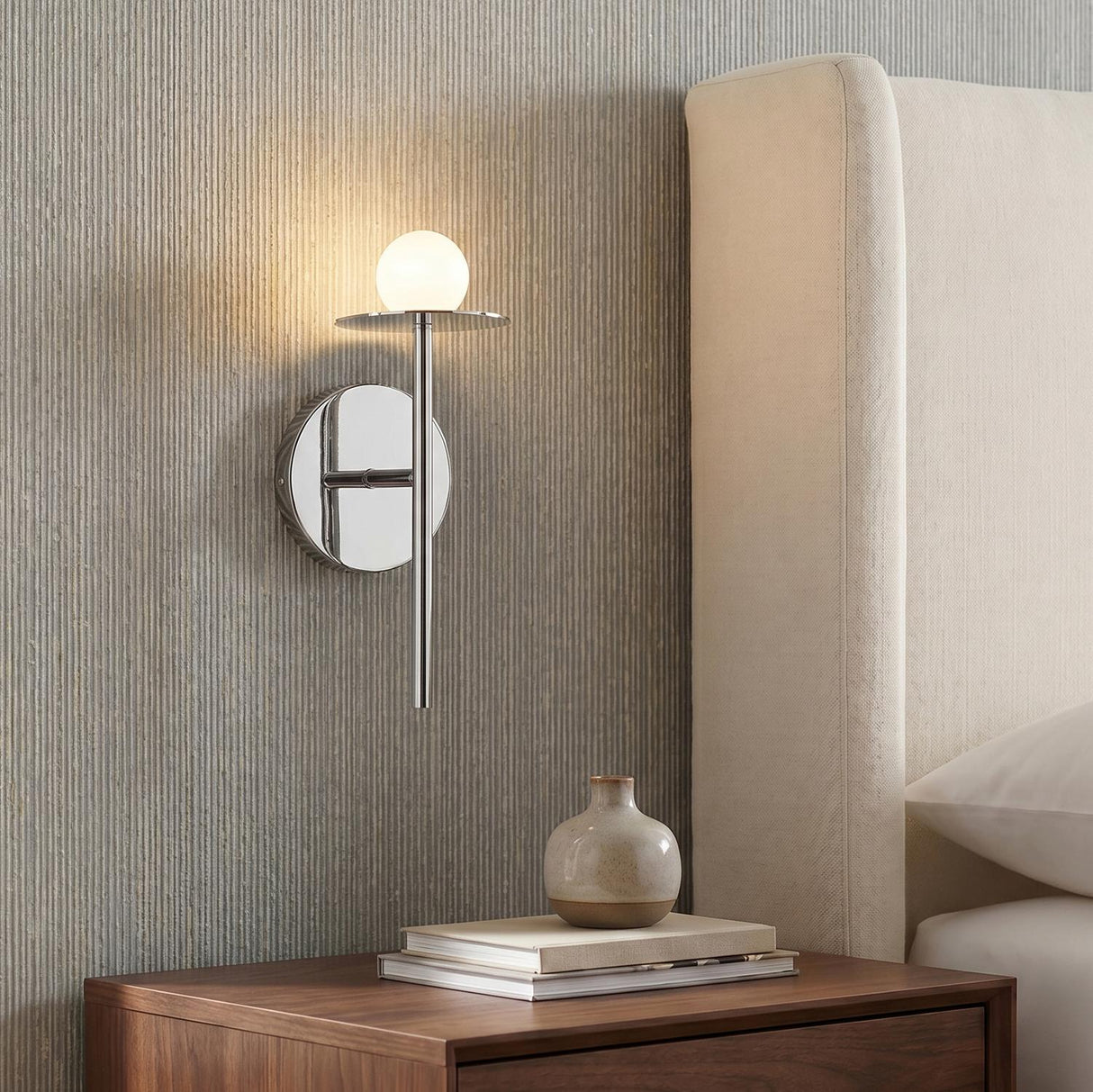 Sol LED Wall Sconce 10", Chrome globe Wall Sconce in a Modern Bedroom with a cream upholstered headboard.
