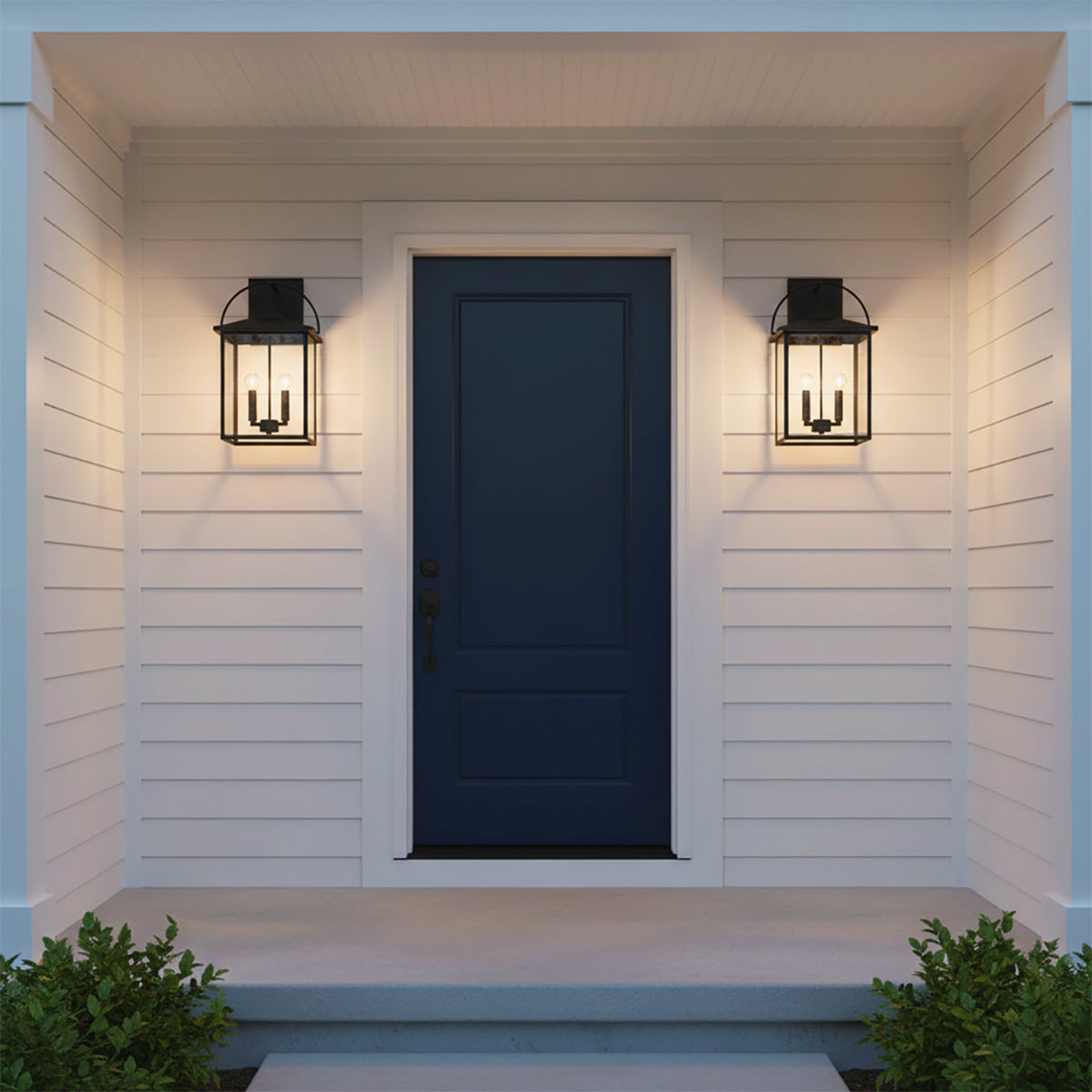 Darby Outdoor Wall Light, Medium 20" Black - Two black lanterns flanking a navy blue front under a porch.