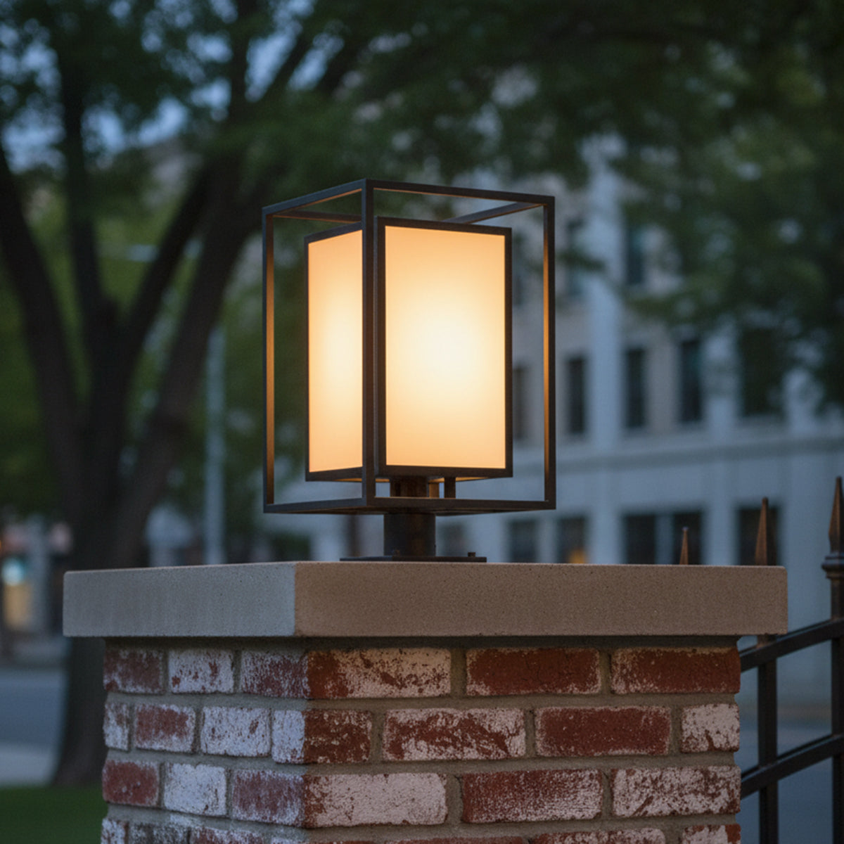 Orley Outdoor Post Light, Black - An illuminated square post light with a black frame atop a brick pillar.