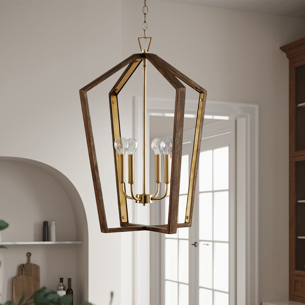 Wooden pendant light with gold accents hanging in a room with a door and shelves in the background.