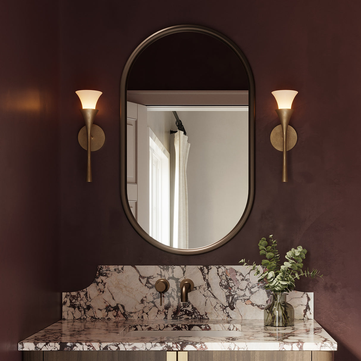 Deep burgundy powder room with marble countertops and two Fleur Wall Sconces in Textured Brushed Brass finish on either side of the mirror