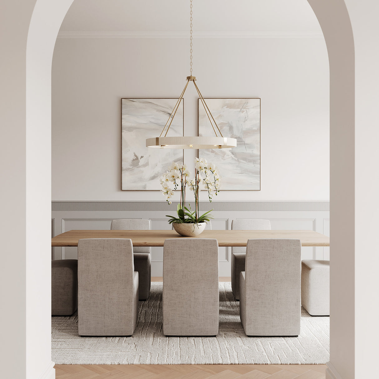 Modern dining room with a long table and eight chairs, featuring the Saltair Ring Chandelier 36", Matte Brass with Natural Rope.