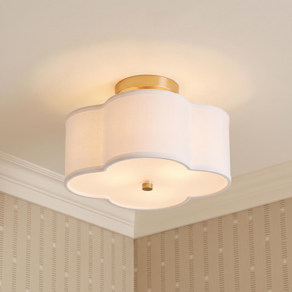 A transitional foyer with the Orla Semi-Flush 12", Brushed Gold featuring a scalloped white linen shade along the ceiling with beige wallpaper and white molding.
