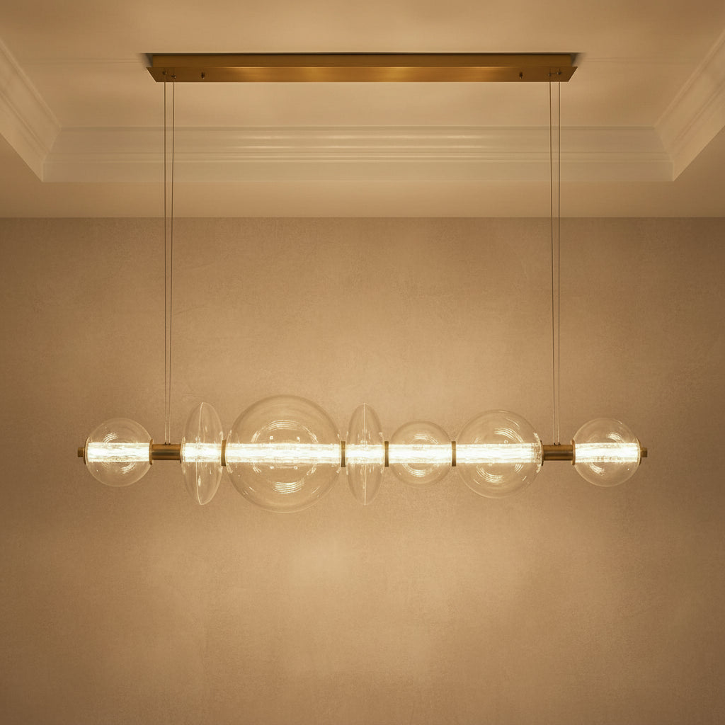 Elara LED 7 Light Linear Chandelier 56", Brass and Clear Glass for Modern home with Textured Beige Walls