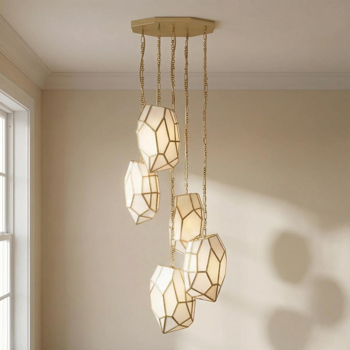 Facet 5 Light Chandelier, Antique Brass geometric Chandelier in a Transitional Living Room with beige walls and crown molding.