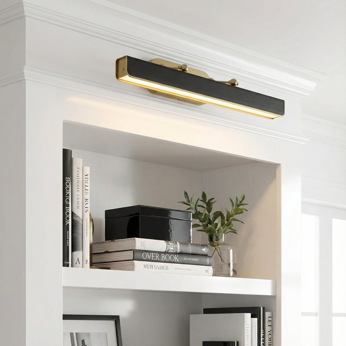 Jarrett LED Picture Light 32", Aged Brass & Tuxedo Leather linear wall sconce in a Transitional Living Room with a white built-in bookshelf.