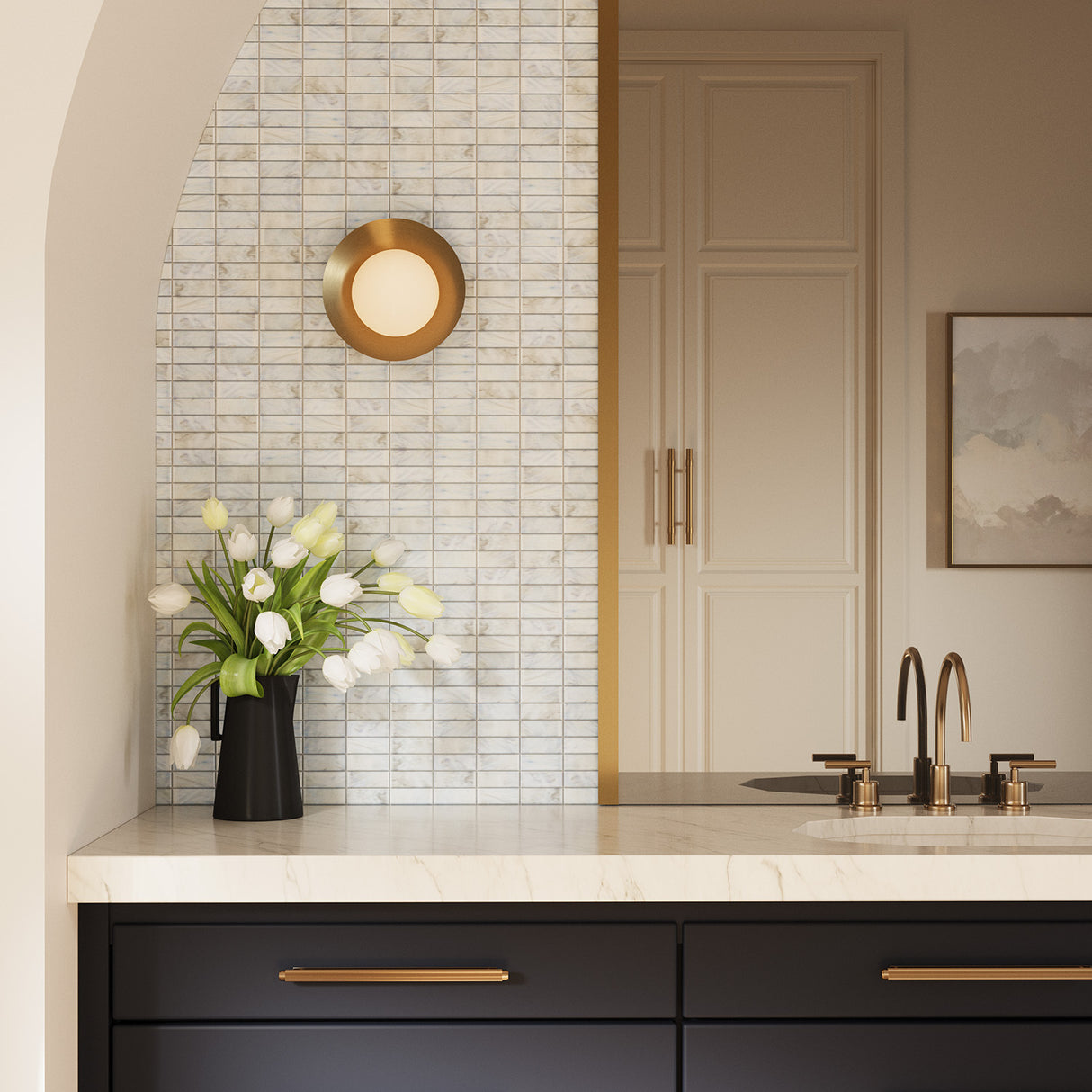 Elon 9" Wall Sconce in Brass finish is shown next to a contemporary bathroom vanity with black drawers and brass hardware.