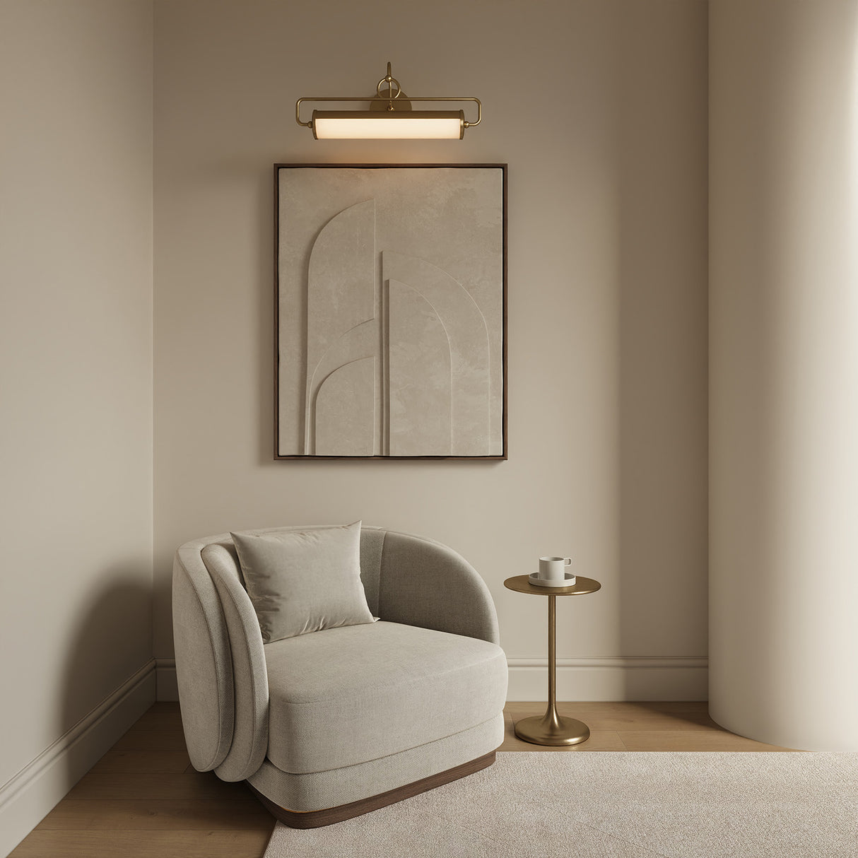 Dodie LED Picture Light 21", in Brushed Brass is shown above a piece of modern art in a living room, with a curved chair and brass side table.