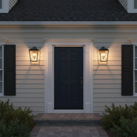 Harrison Outdoor Large Wall Light 16, Textured Black - Two outdoor lanterns flanking a dark blue door with white trim, illuminated at dusk.
