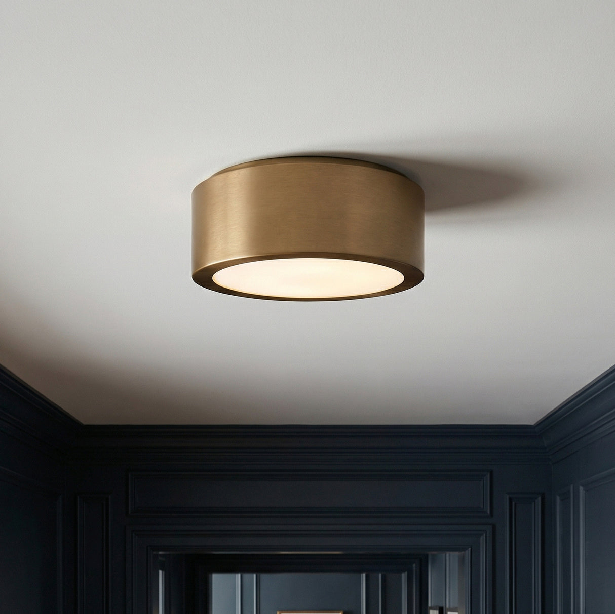 Satin Brass geometric flush mount in a Transitional Entryway with dark paneled walls.