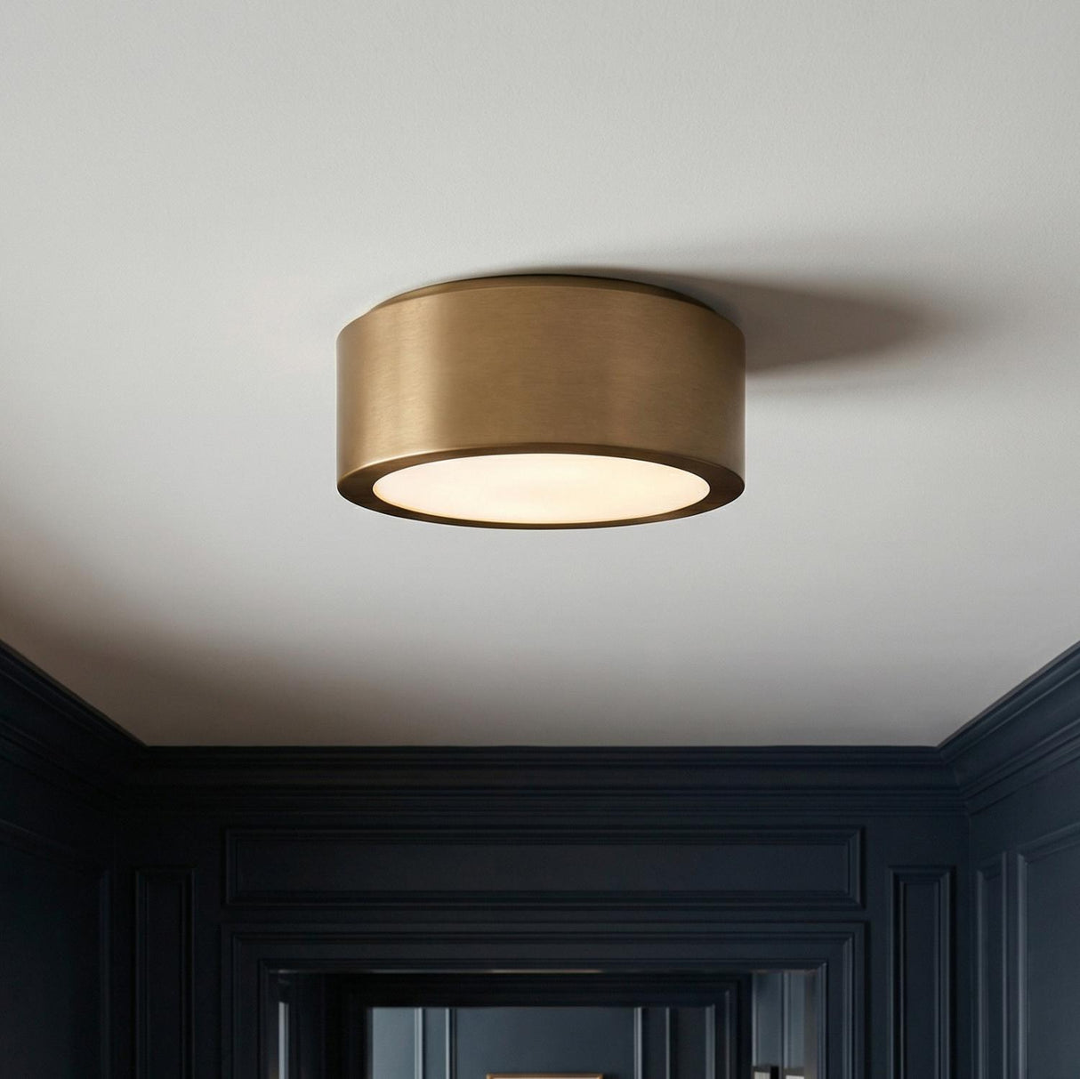 Satin Brass geometric flush mount in a Transitional Entryway with dark paneled walls.