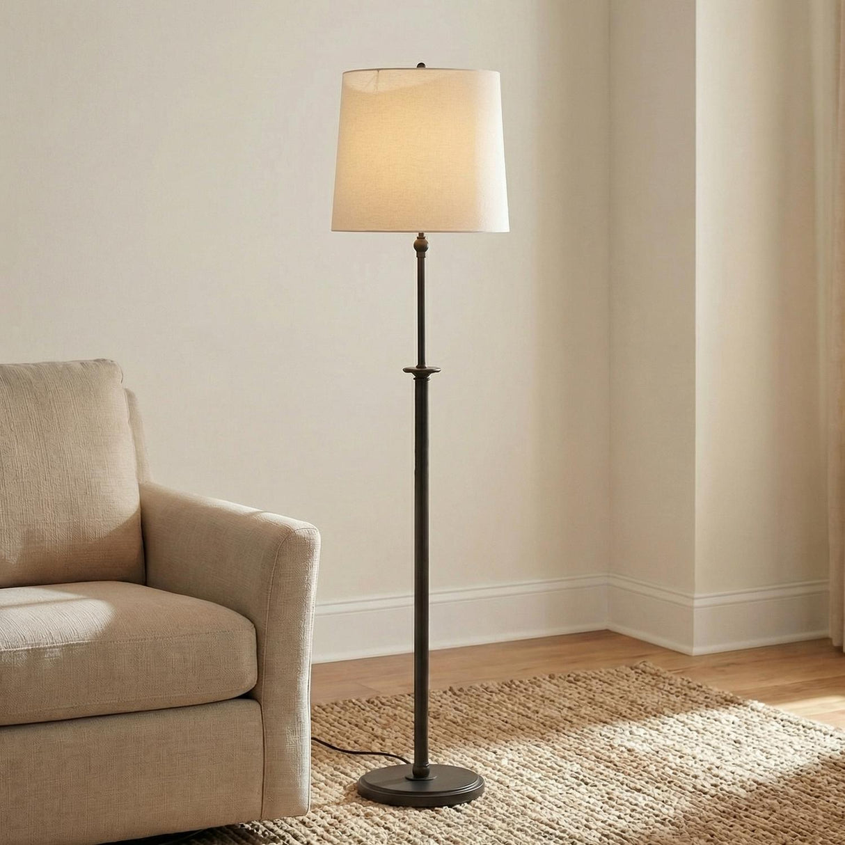 Emerson Floor Lamp, Aged Iron linear Floor Lamp in a Transitional Living Room with a textured beige armchair and jute rug.