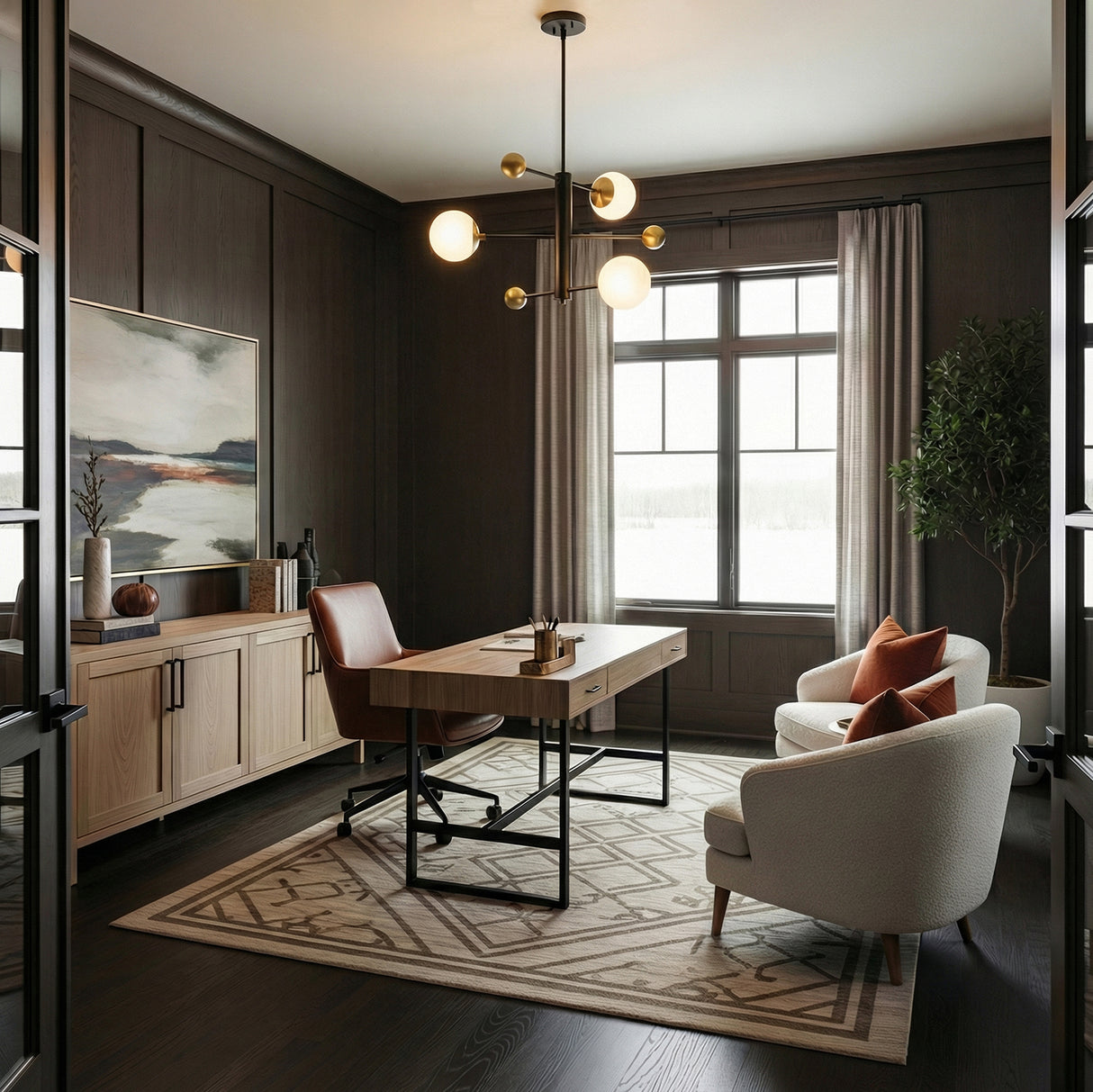 Modern home office with a desk, two arm chairs, and dark walls, with the Jubilee Adjustable 31" Chandelier in Black and Brass hanging above the desk