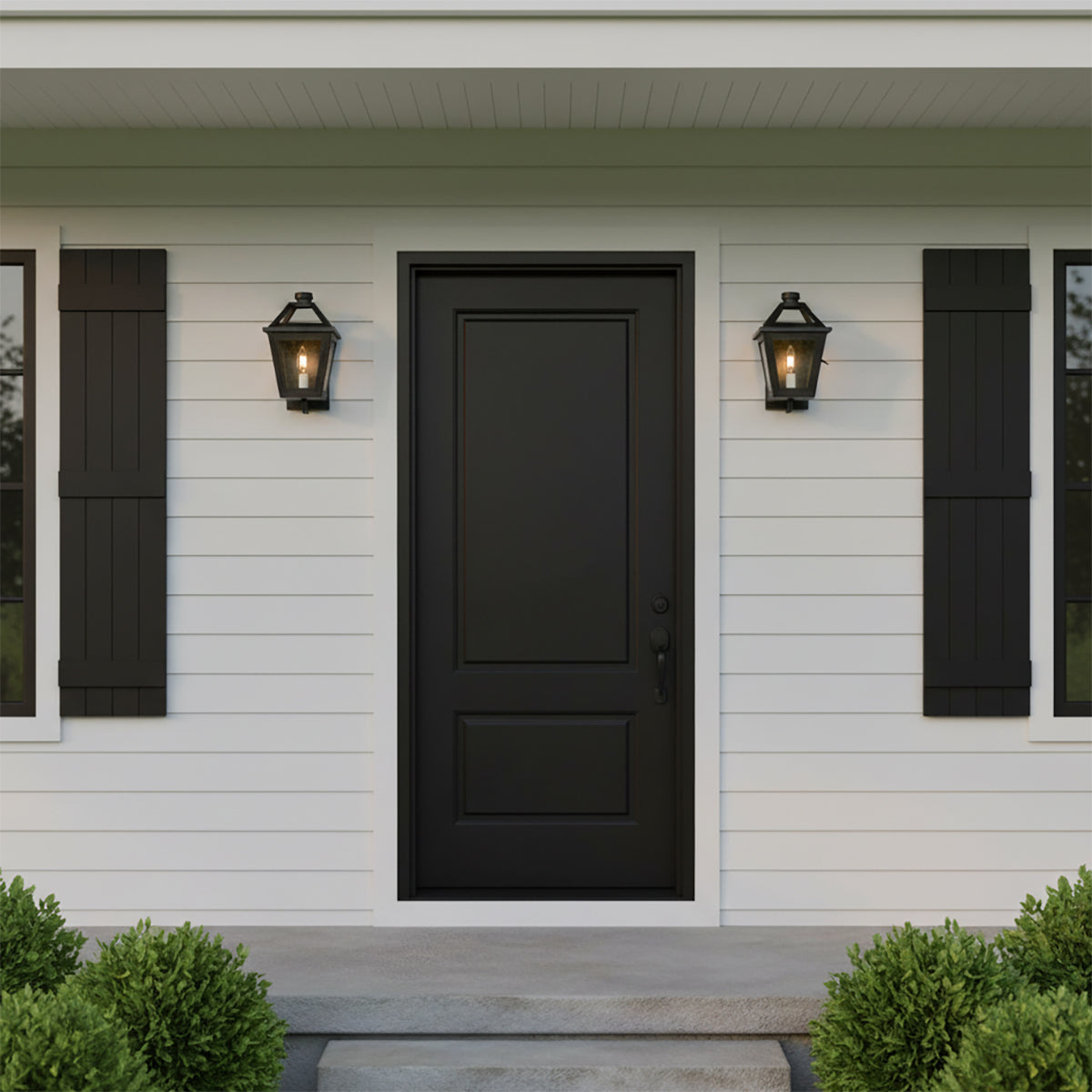 Fairmont Extra Small Outdoor Wall Light in Textured Black - Two black outdoor wall lights flank a black front door on a white-paneled house with black shutters and green bushes.