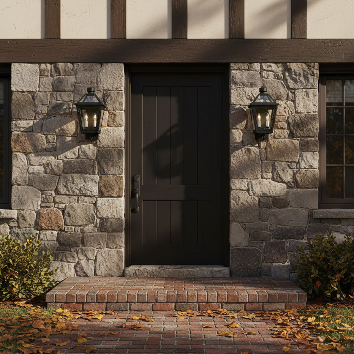 Fairmont Small Outdoor Wall Light - Two black lanterns flanking a dark door on a stone-clad exterior with autumn leaves.