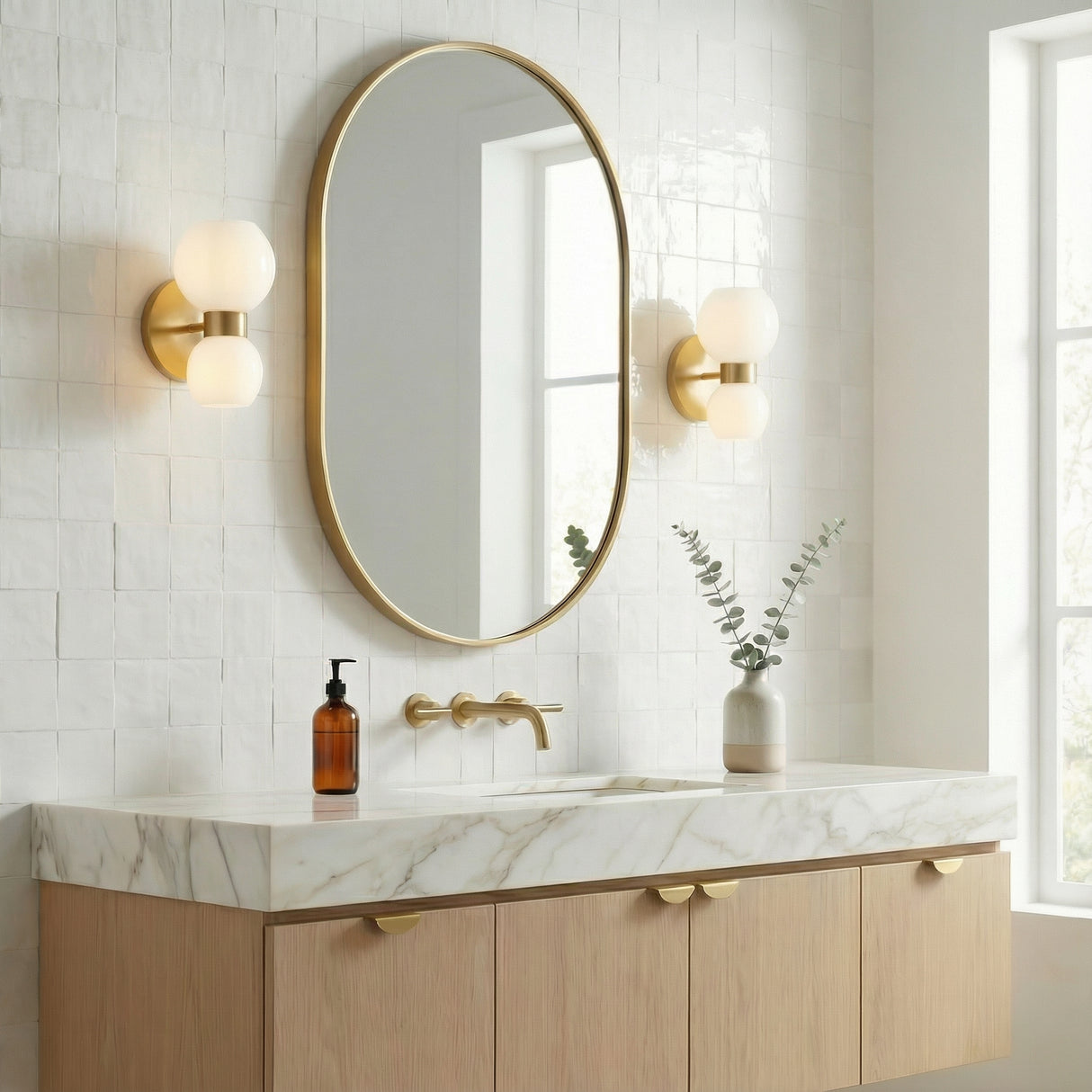Matilda Modern Brass and Milk Glass globe wall sconce in a Contemporary Bathroom with a white marble vanity and oval mirror.