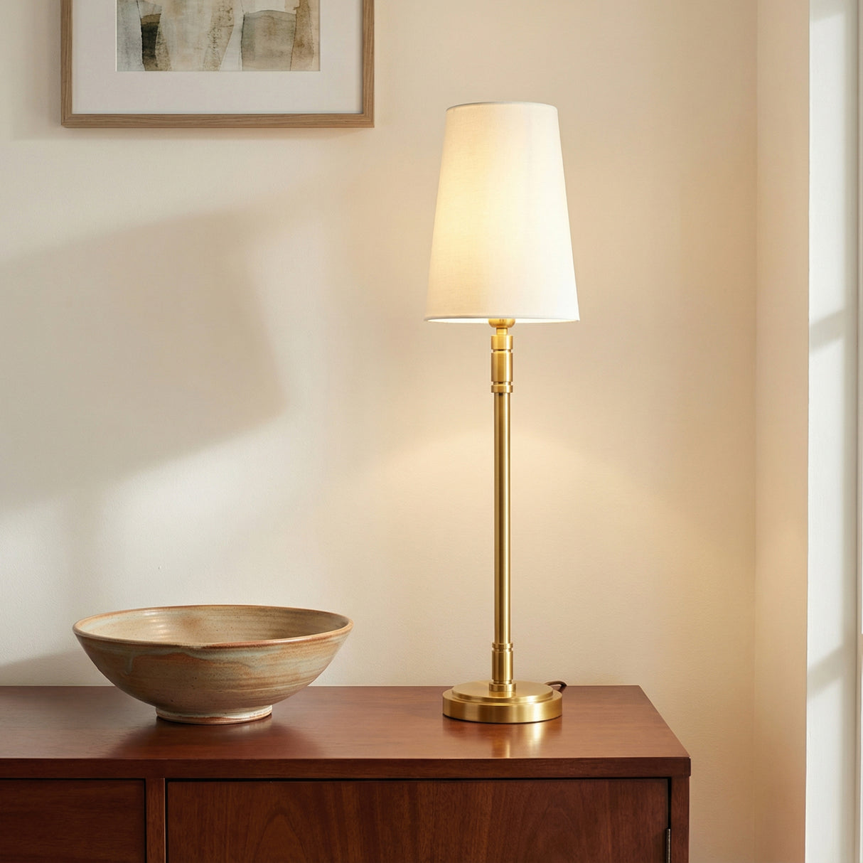 Petra Buffet Lamp 27, Modern Brass, in a Modern Living Room with a wooden buffet.