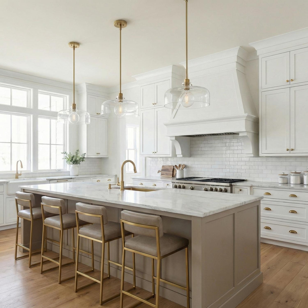 Alder Pendant 15", Satin Brass and Clear Glass globe pendant in a Transitional Kitchen with a white marble island and gold stools.
