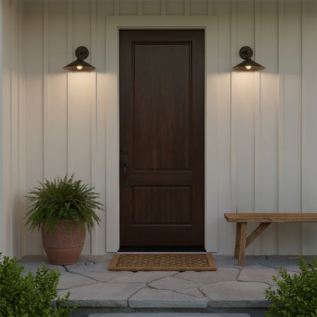 Artie Outdoor Wall Light, Medium Antique Bronze - Two antique bronze wall lights flank a dark wood door with a potted fern and a wooden bench.