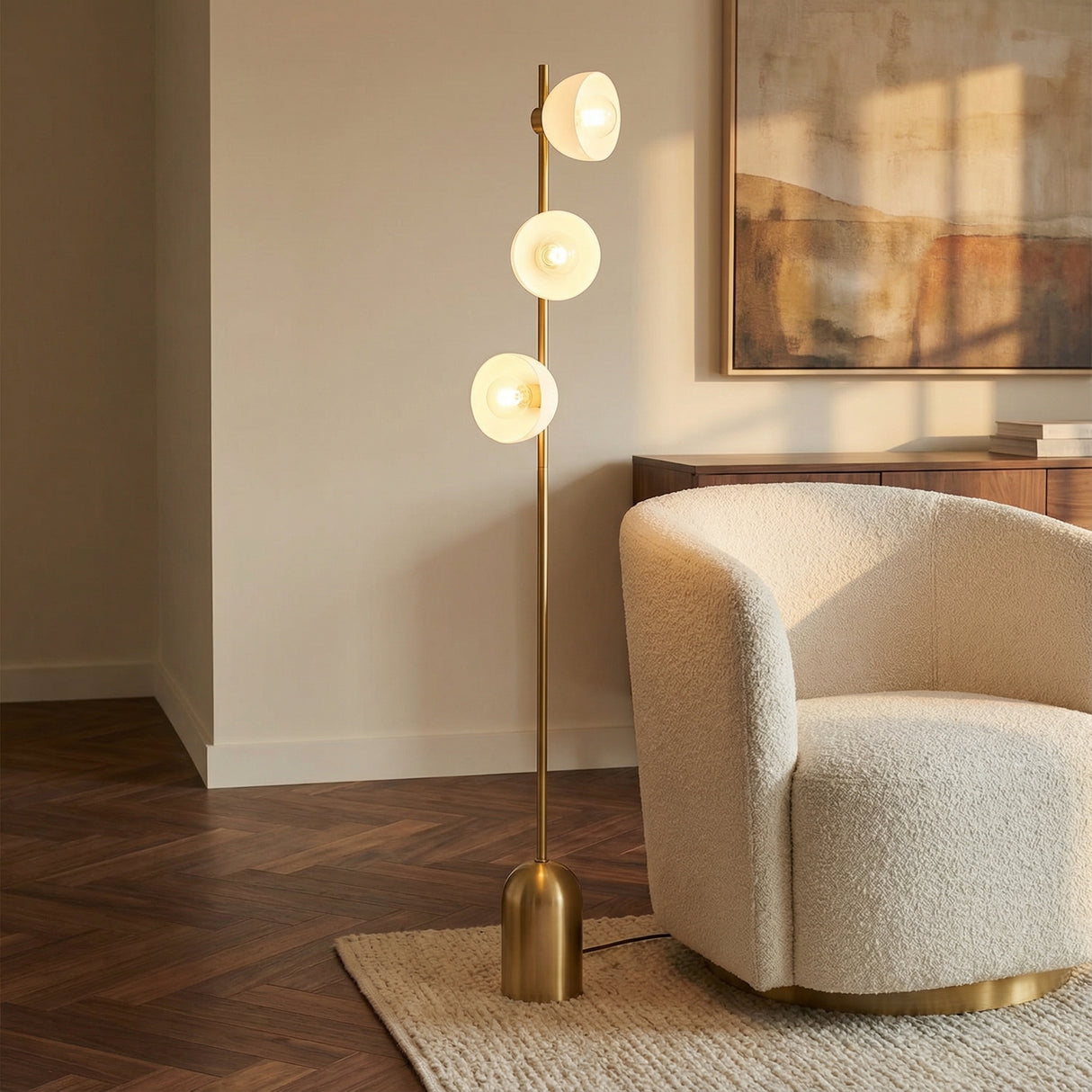 Penrose Floor Lamp, Aged Brass globe floor lamp in a Modern Living Room with a cream bouclé armchair.