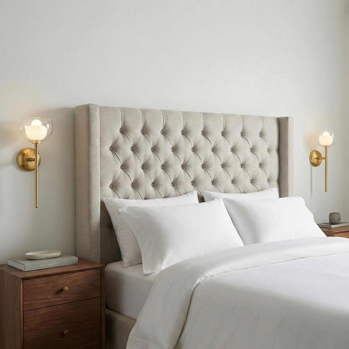 Rhett Wall Sconce 17", Aged Brass globe Wall Sconce in a Transitional Bedroom with a tufted headboard and walnut nightstand.