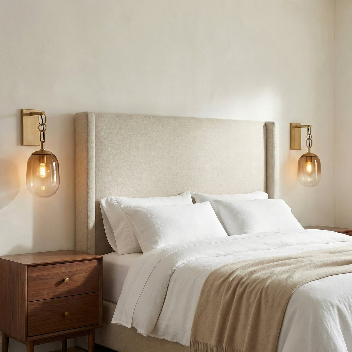 Blythe Wall Sconce Patina Brass and Topaz Gradient Glass globe wall sconce in a Transitional Bedroom with a beige upholstered headboard.