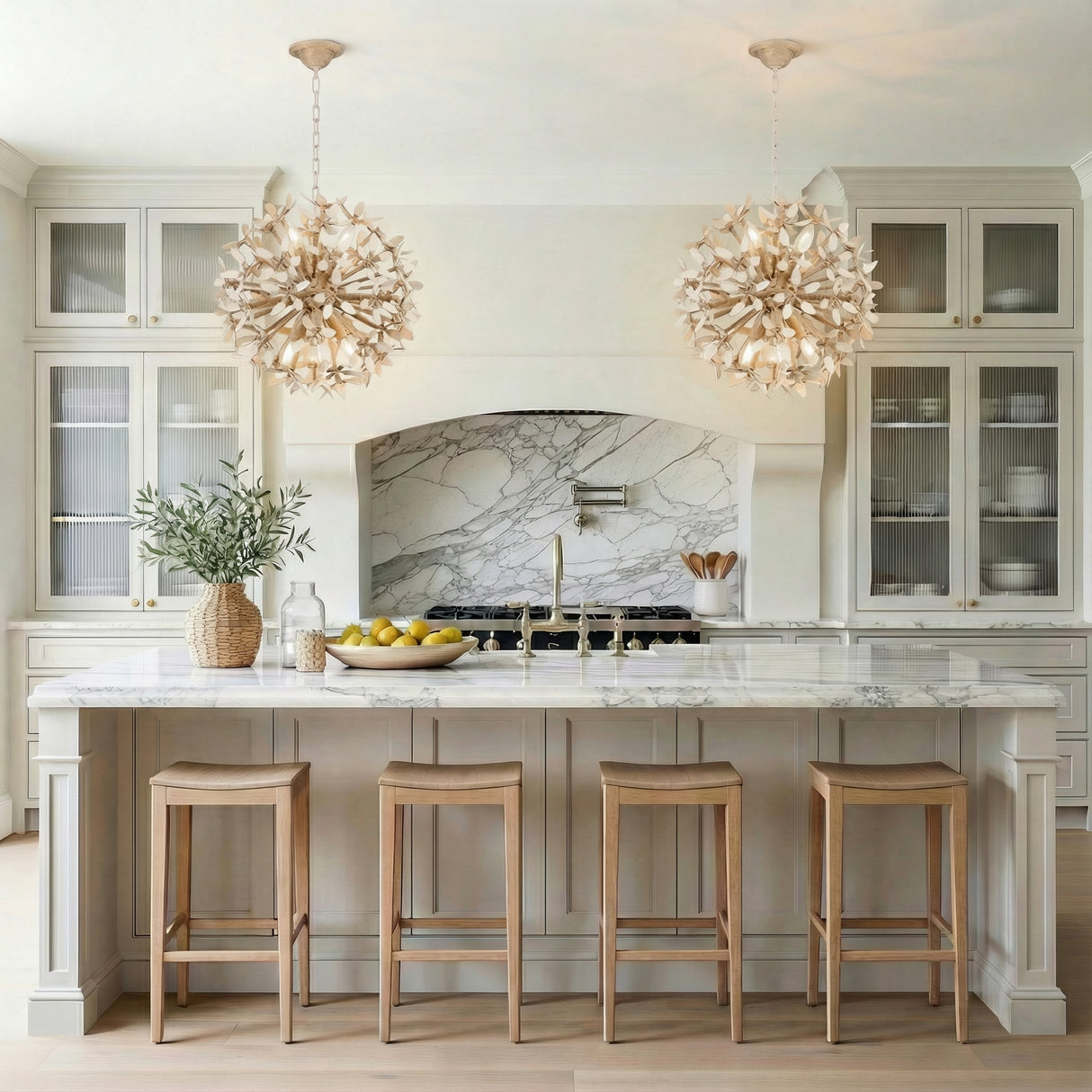 Weathered Gold leaf design pendant in a Transitional Kitchen with a white marble island & natural wood stools.