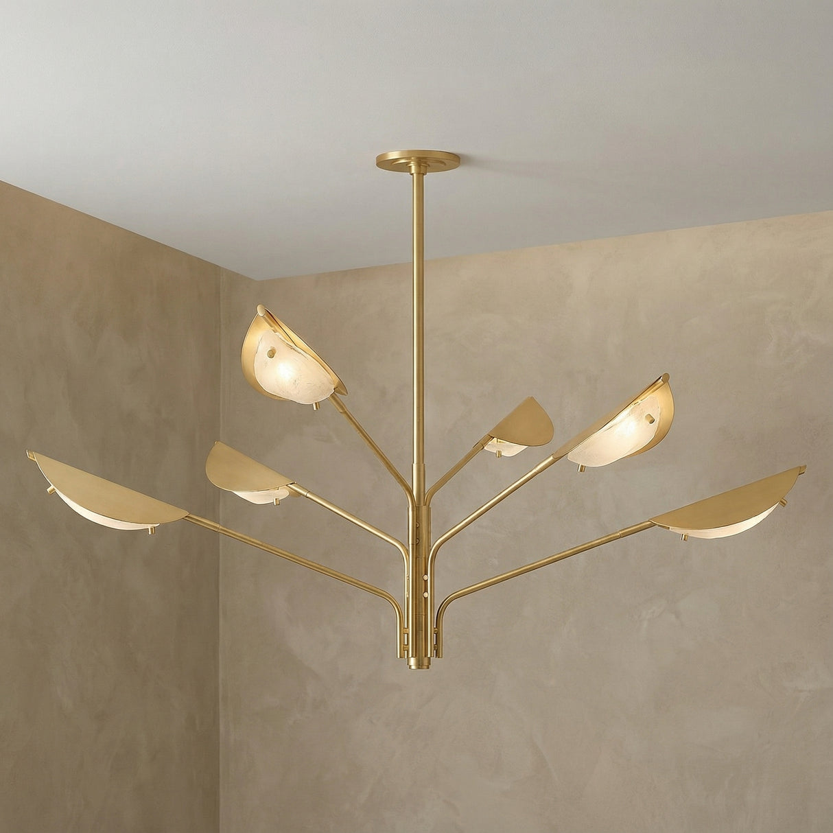Gabrielle 6 Light Chandelier 54", Aged Brass with Art Glass leaf design Chandelier in a Modern Living Room with a textured plaster wall.