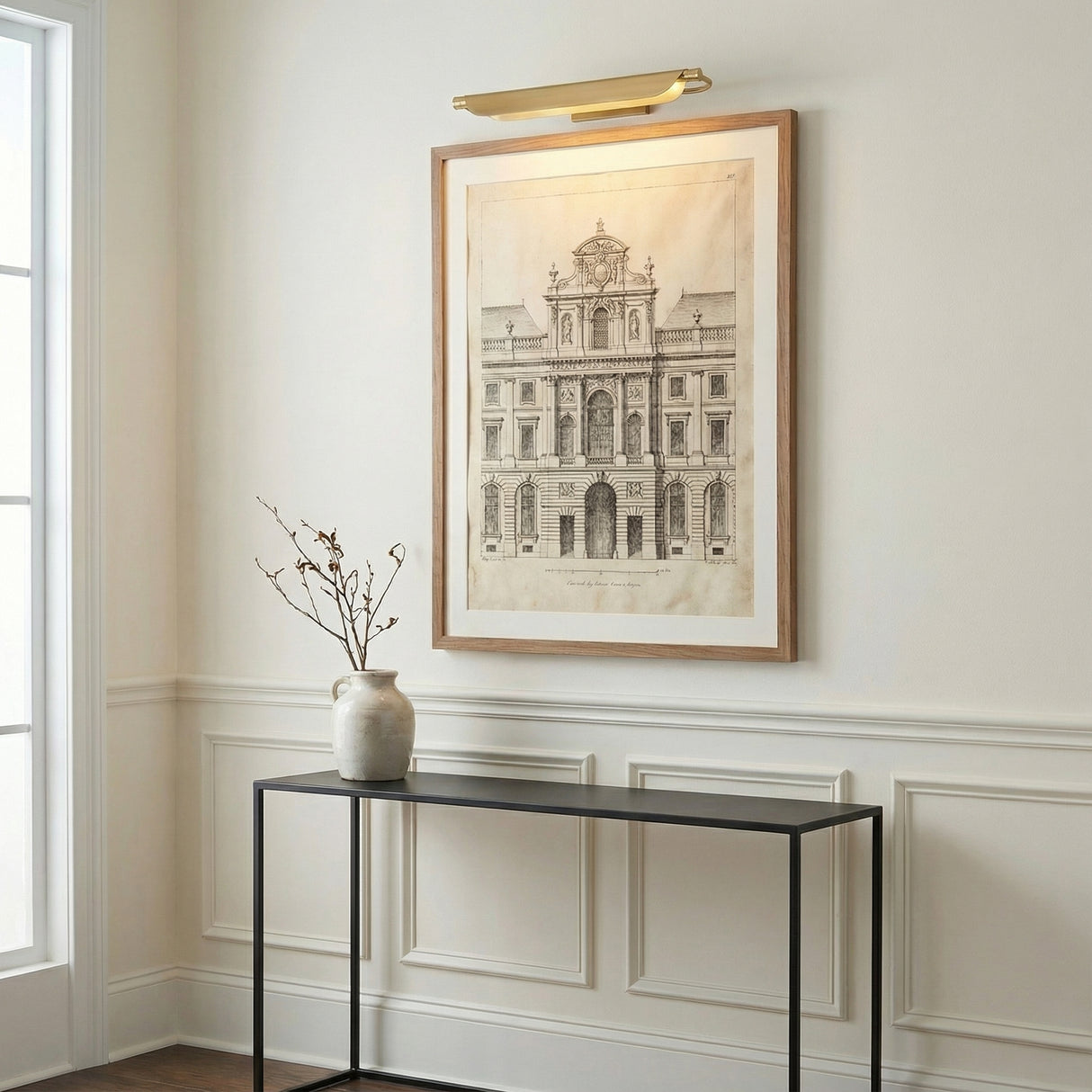 Mitchell LED Picture Light 27", Aged Brass linear picture light in a Transitional Entryway with a black console table.