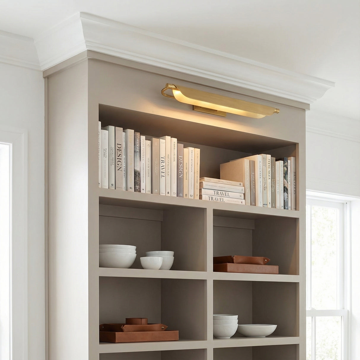 Mitchell LED Picture Light 27", Aged Brass linear Wall Sconce in a Transitional Living Room with a built-in bookshelf.