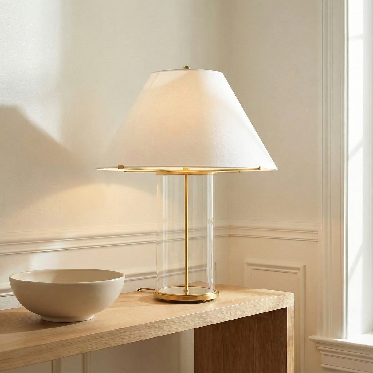 Elena Table Lamp, Aged Brass and Clear Glass linear Table Lamp in a Transitional Entryway with a light wood console table and paneling.