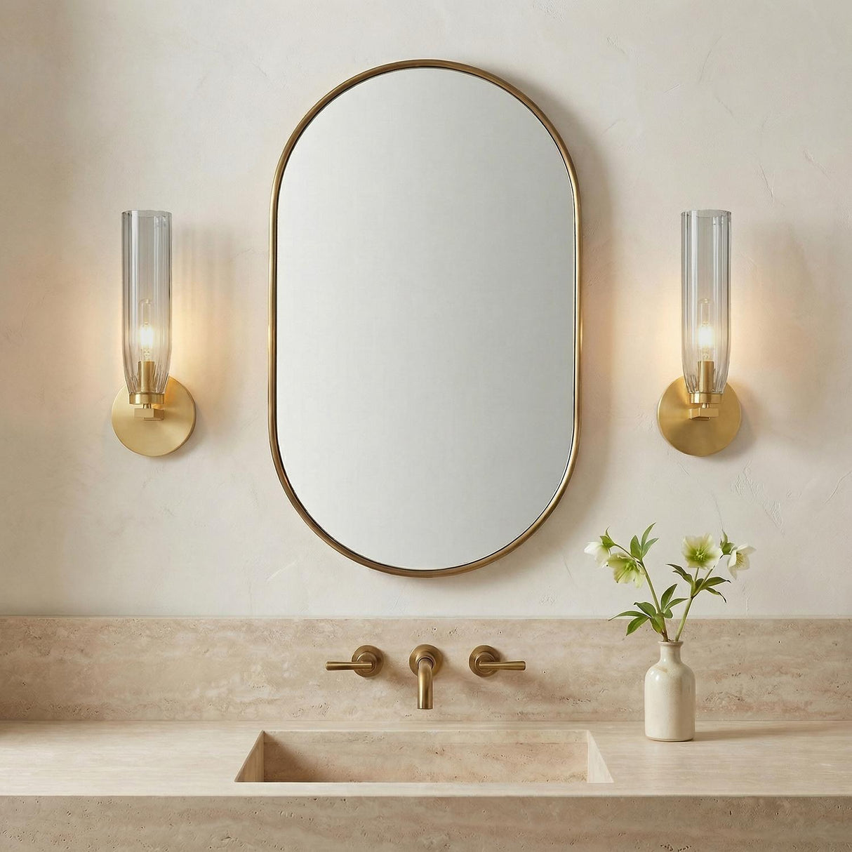 Ernest Wall Sconce 14", Aged Brass and Smoke Glass linear wall sconce in a Transitional Bathroom with a travertine vanity and oval mirror.