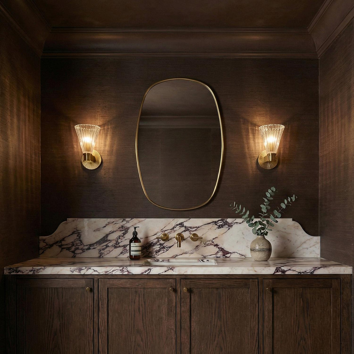 Eliza Wall Sconce 9", Brass and Clear Ribbed Glass Brass scalloped Wall Sconce in a Transitional Bathroom with a white marble backsplash.