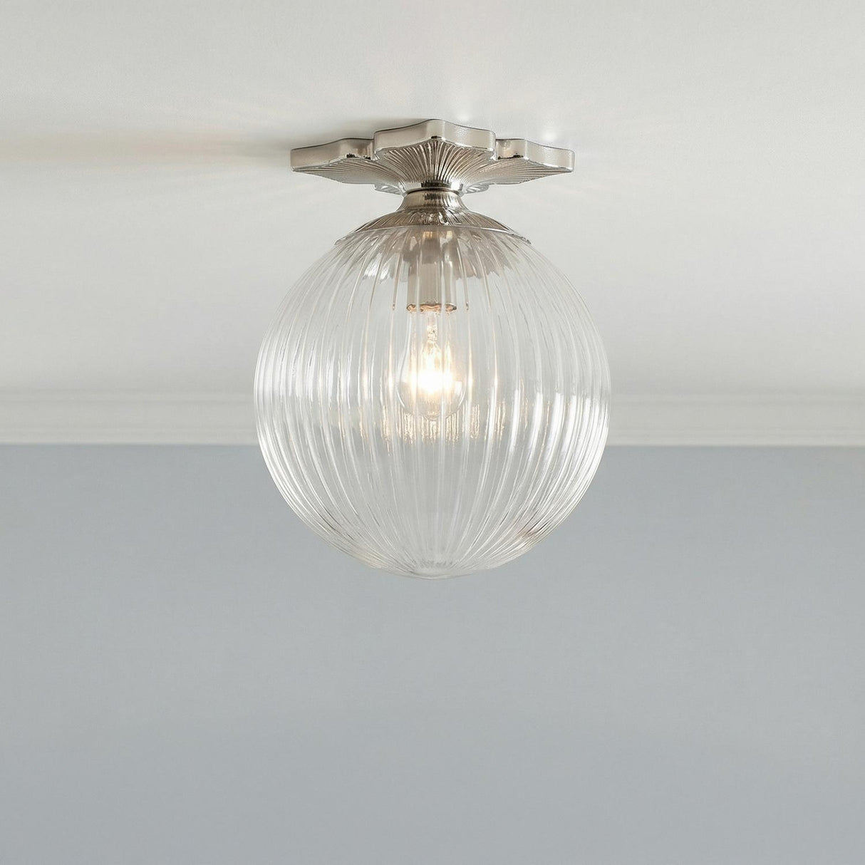 Victoria Semi-Flush 10", Polished Nickel and Clear Ribbed Glass globe Flush Mount in a Transitional Hallway with soft blue walls.