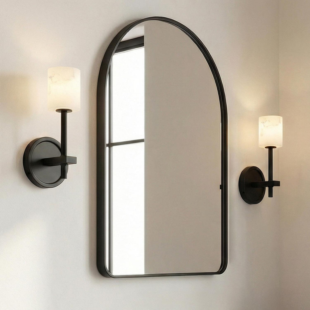 Arlo Wall Sconce 11", Matte Black and Alabaster geometric Wall Sconce in a Modern Bathroom with an arched black mirror.