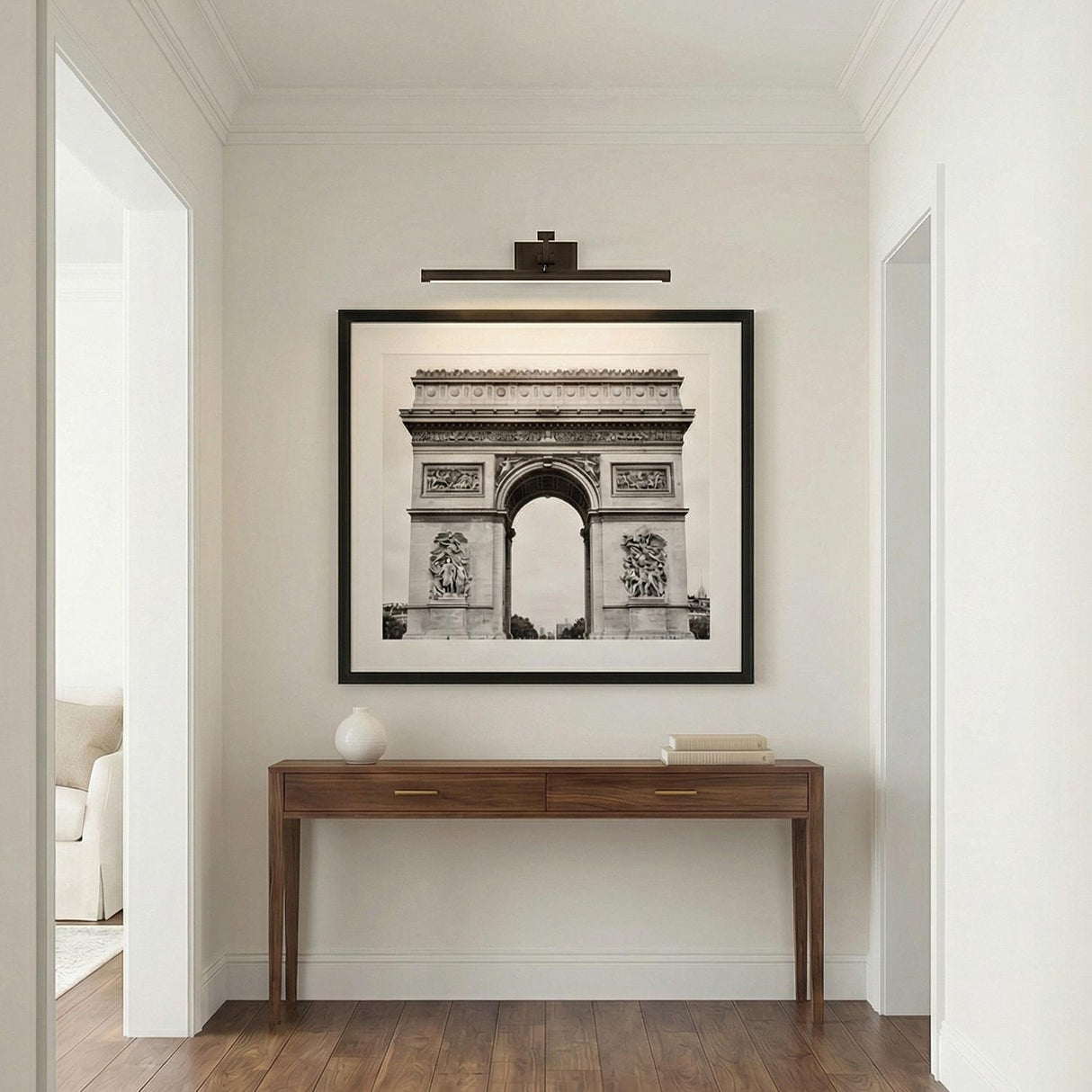 Roland LED Picture Light 24", Bronze linear Wall Sconce in a Transitional Hallway with a walnut console table and framed art.