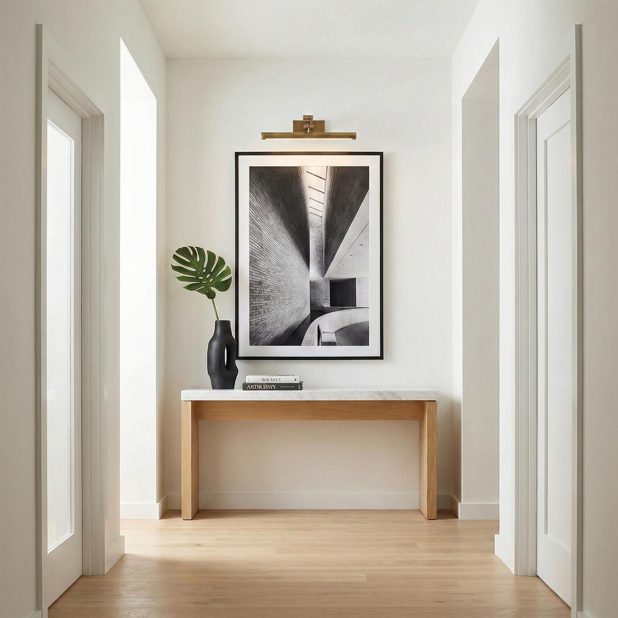 Roland LED Picture Light 16", Patina Brass linear Picture Light in a Modern Hallway with a marble top console and framed art.