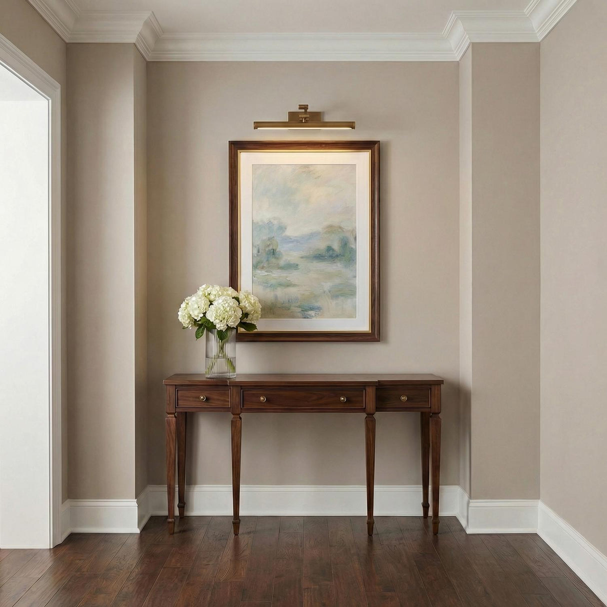 Roland LED Picture Light 16", Patina Brass linear Wall Sconce in a Traditional Entryway with a dark wood console and framed art.