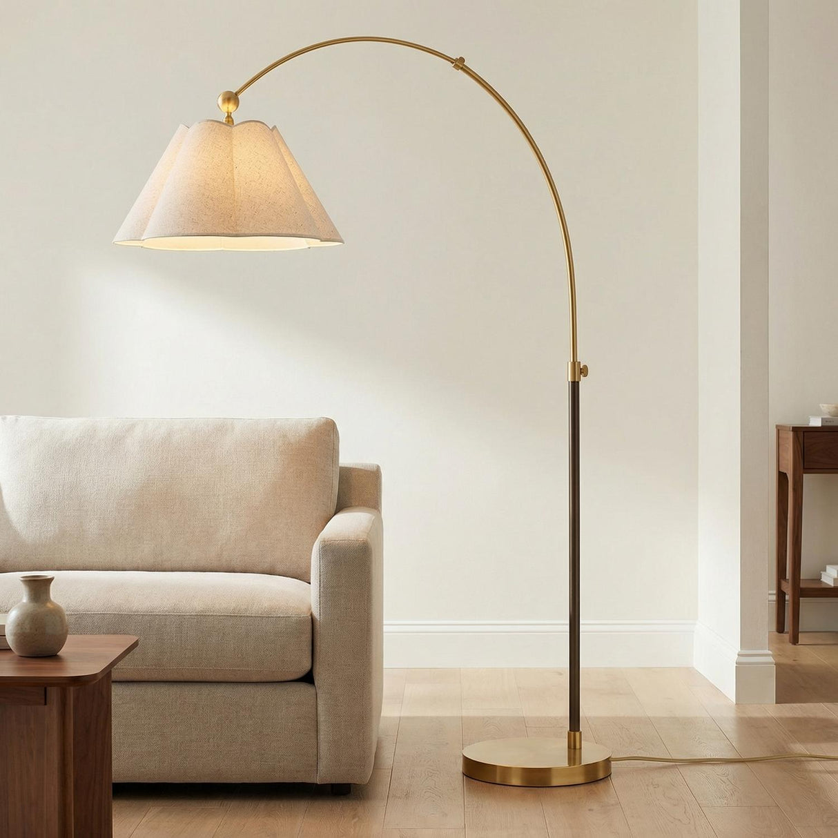 Sara Arched Floor Lamp 70", Aged Brass and Bronze scalloped Floor Lamp in a Transitional Living Room with a cream sofa and wood table.