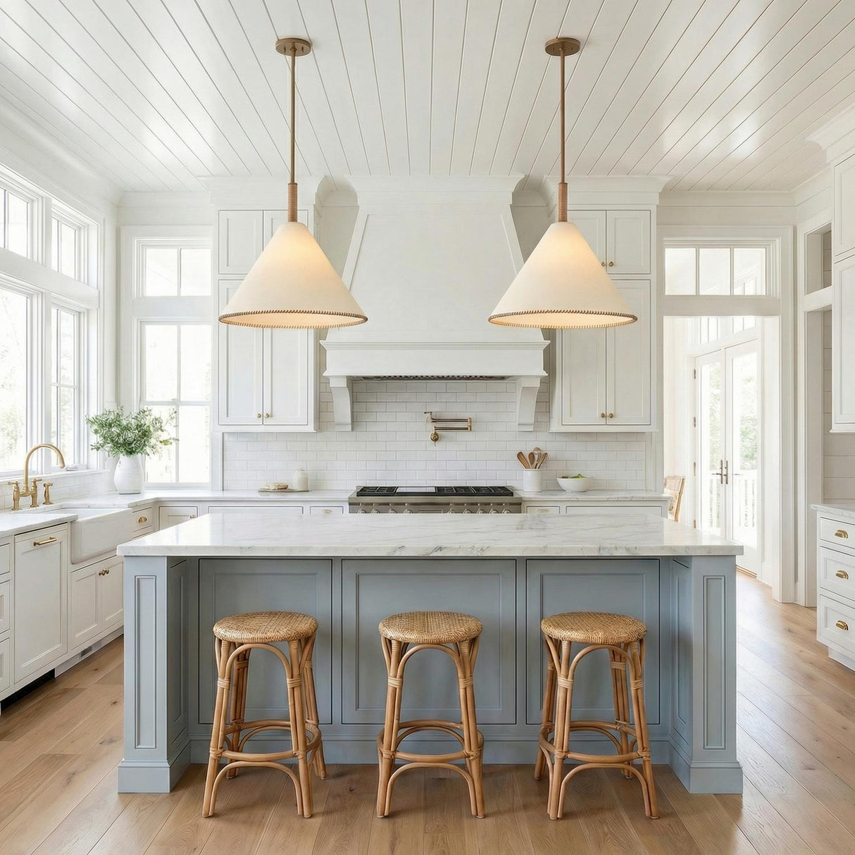 Delora Pendant 24", Patina Brass and Rattan woven cone Pendant in a Coastal Kitchen with a white marble island and rattan stools.
