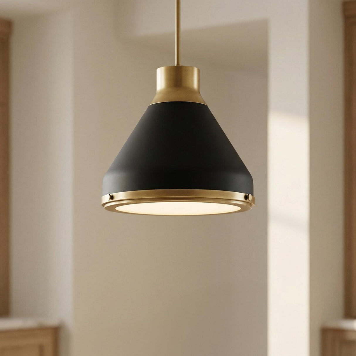 A transitional kitchen features the Drew Medium Pendant 19 inch in Matte Black and Aged Brass suspended along the ceiling near light wood cabinets and white walls.