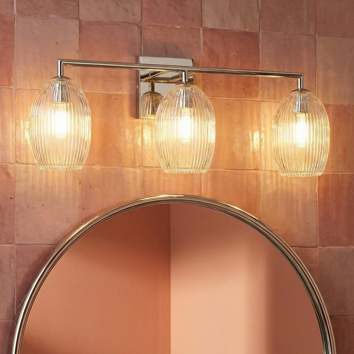 Fiora 3 Light Vanity 27", Polished Nickel globe Vanity in a Contemporary Bathroom with terracotta tiles and a round mirror.