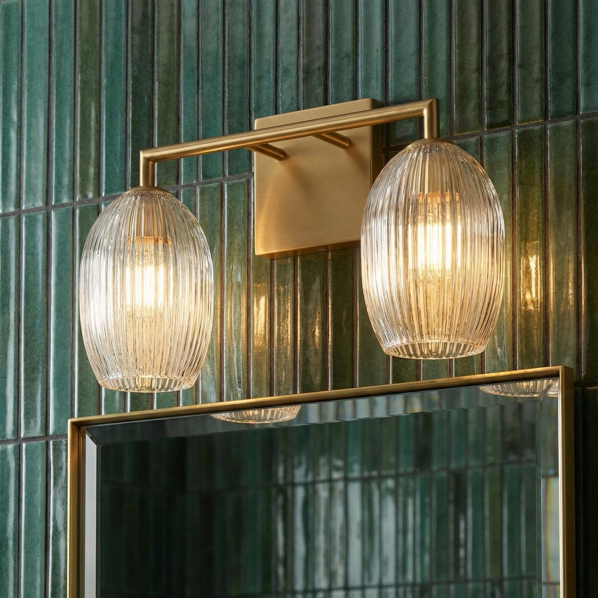 Fiora 2 Light Vanity 16", Modern Brass globe Vanity in a Contemporary Bathroom with green tiled walls and a brass mirror.