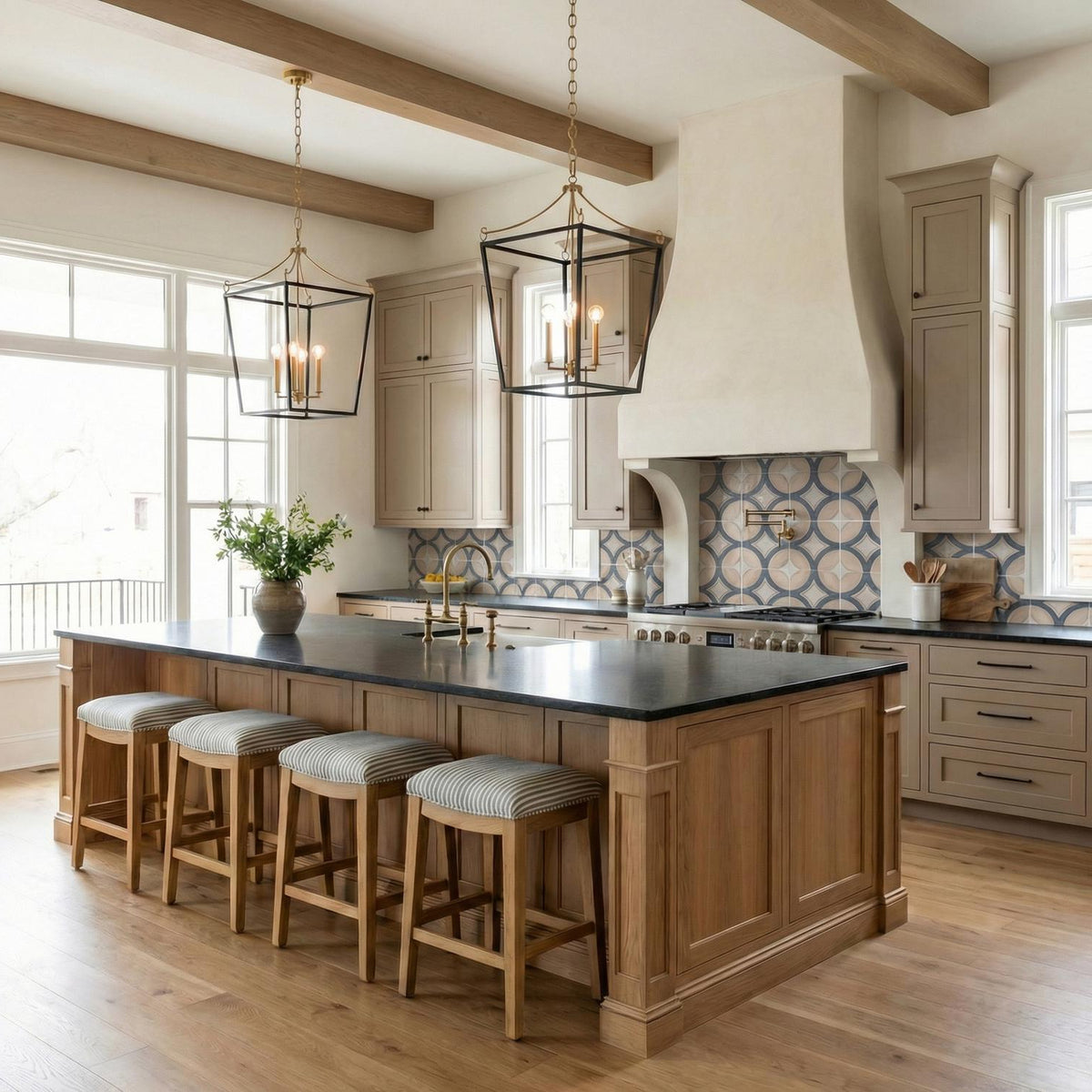 A transitional kitchen with two Cambria Large Lantern Pendant 21", Matte Black and Modern Brass fixtures over a wood island and patterned backsplash under a beamed ceiling.