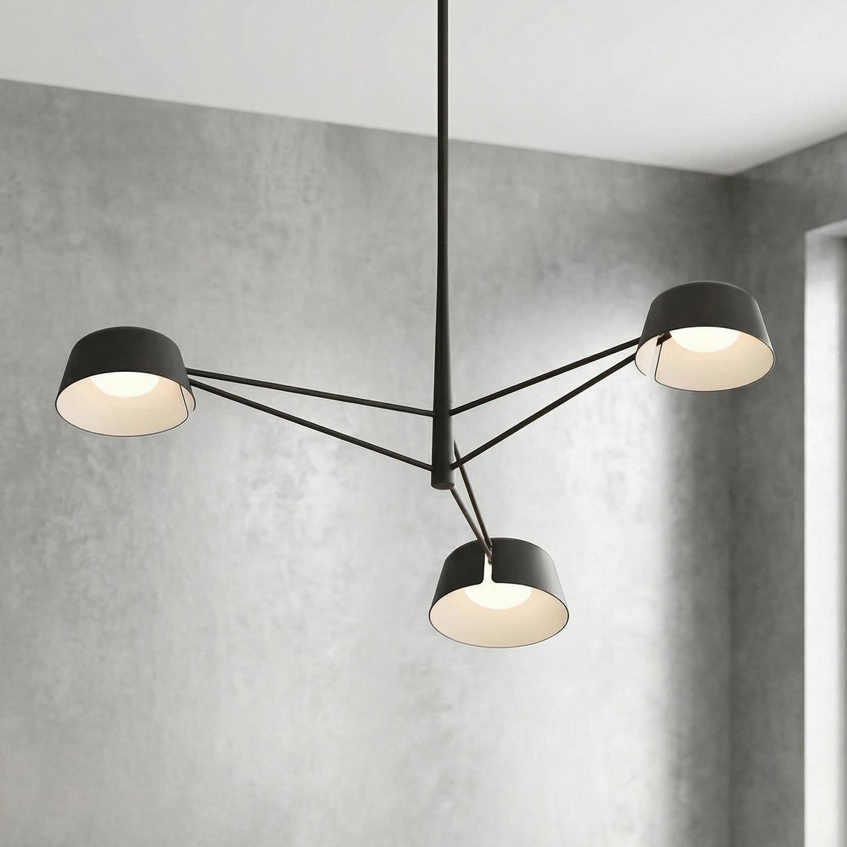 Jude LED 3 Light Chandelier 36", Black geometric Chandelier in a Modern Living Room with a textured gray concrete wall.