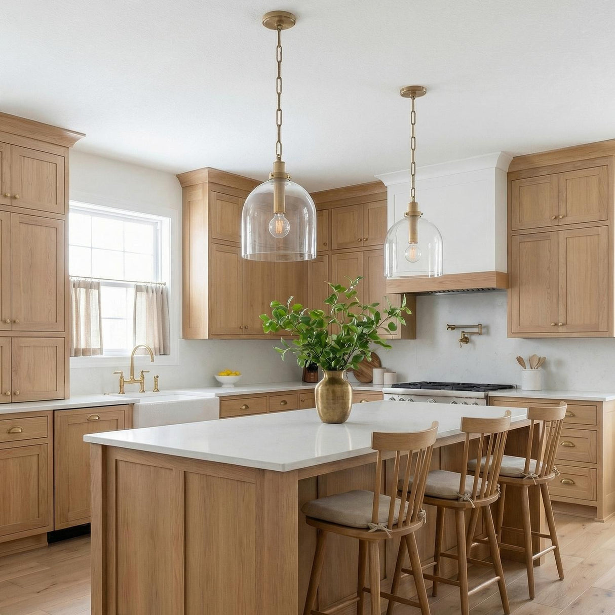 Patina Brass globe glass pendant in a Modern Farmhouse Kitchen with a white marble island and light oak cabinets.