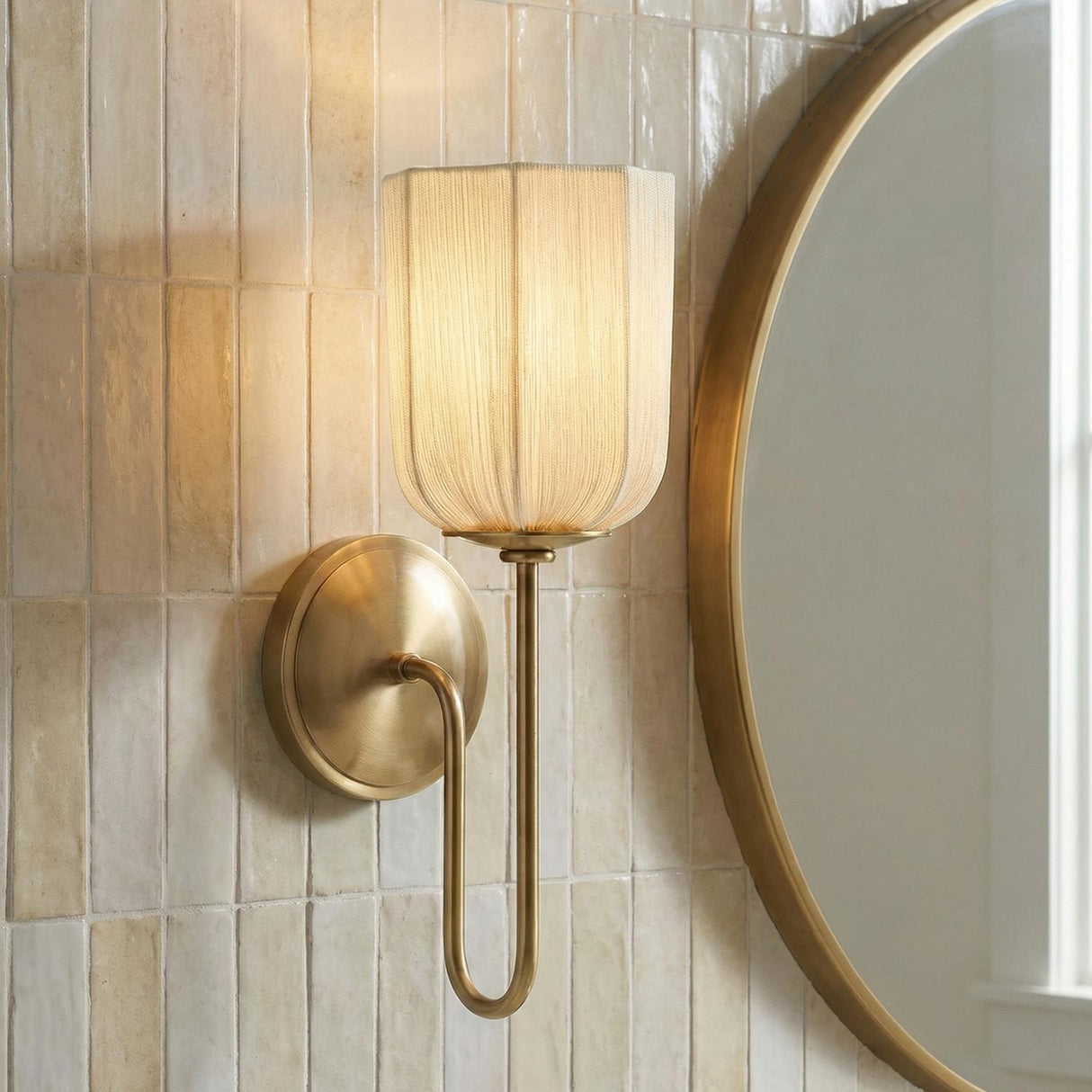 Lilith Wall Sconce 15", Aged Brass scalloped fabric shade Wall Sconce in a Transitional Bathroom with cream subway tile and a gold mirror.