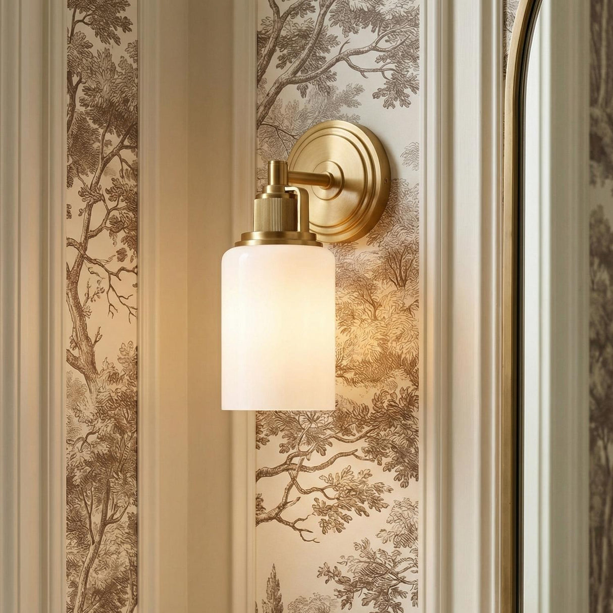 Claxton Wall Sconce 11", Modern Brass geometric wall sconce in a Traditional Bathroom with woodland wallpaper and an arched mirror.